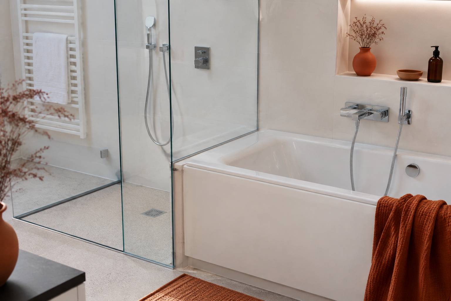 Raccordement soigné entre baignoire et douche à l'italienne avec paroi vitrée et mitigeur chromé